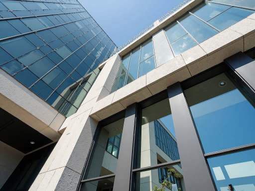 现代化清洁能源技术研发中心外景，玻璃幕墙建筑，绿色植被环绕，阳光充足明亮自然光